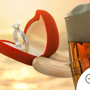 May include: A red velvet ring box with a diamond engagement ring inside, held by a hand reaching towards a glass of beer with a thick head of foam.