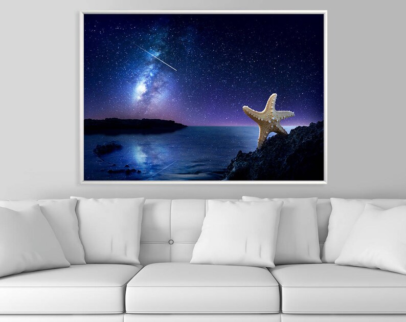 May include: A starfish on a rocky shore under a night sky with a bright Milky Way galaxy and a shooting star.