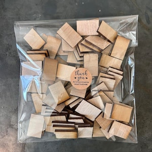 May include: A clear plastic bag filled with numerous small, rectangular wooden pieces with a light brown grain. A circular tan sticker is attached to the front of the bag, featuring the black text, thank you for supporting my small business.