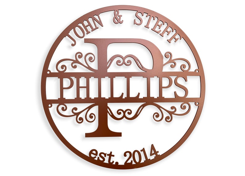 May include: A circular, copper-colored metal sign with the names "JOHN & STEFF" and "PHILLIPS" cut out. The sign includes the year "est. 2014" and decorative flourishes. The letter "P" is prominently displayed.