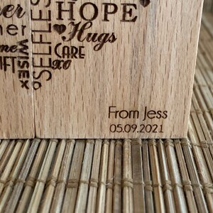 May include: Two wooden blocks with a heart shape design engraved with words like "Hope", "Hugs", "Care", "Gifts", "Home", "Teacher", "Mother", "Wise", "Love", and "From Jess 05.09.2021".