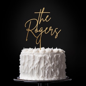 Personalized cake topper placed on a beautifully decorated wedding cake, displaying “Mr & Mrs” with the couple’s last name in an elegant handwritten font.