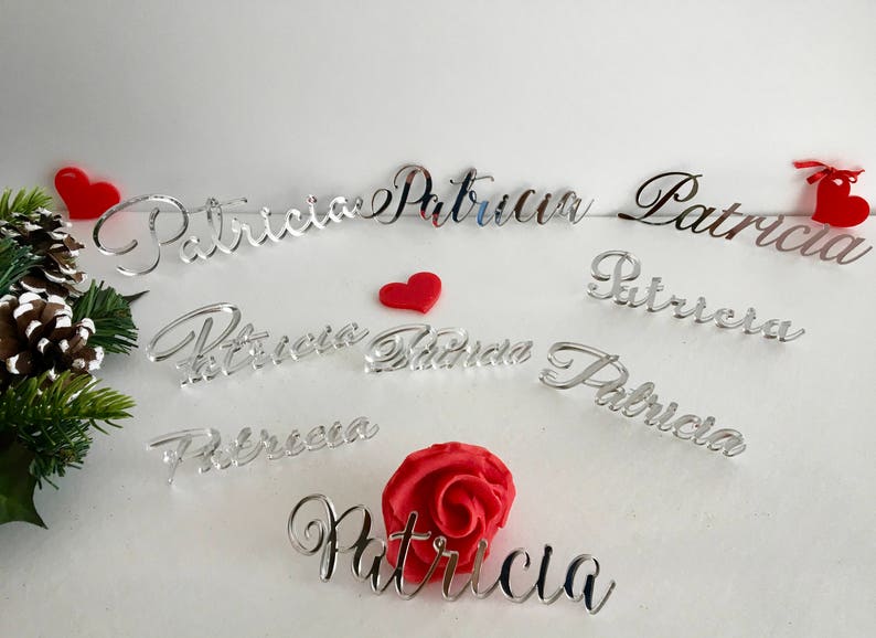 Peut inclure: Une collection de d&eacute;coupes de noms en acrylique argent&eacute; affichant le pr&eacute;nom Patricia dans diverses polices cursives. L'ensemble comprend plusieurs pi&egrave;ces nominatives individuelles, de petits c&oelig;urs rouges et une fleur rose rouge.
