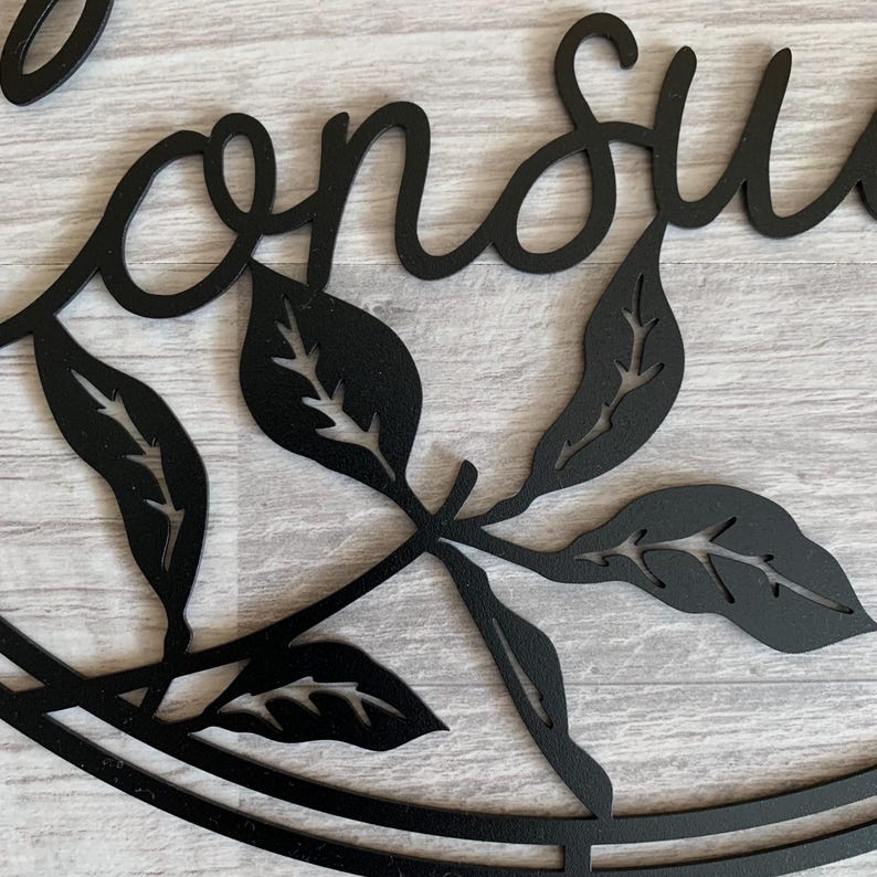May include: Black metal wall decor with the word "Conserve" in a cursive font, surrounded by stylized leaves.