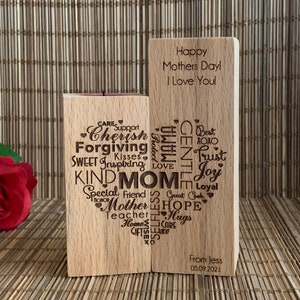 May include: Two wooden blocks with engraved messages. The left block has a heart shape with words like "Cherish", "Forgiving", "Kind", and "Mom" inside. The right block has the message "Happy Mothers Day! I Love You!" and a signature "From Jess 05.09.2021".