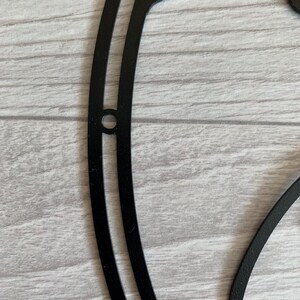 May include: Black metal wall decor in the shape of a yin yang symbol. The symbol is made of two overlapping circles, one black and one white.