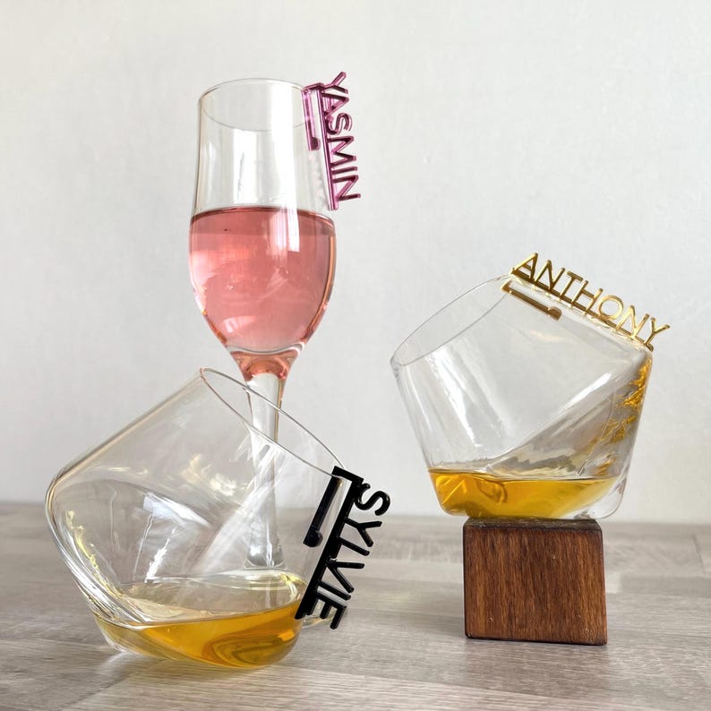 These wine glass charms or pendants are laser cut from acrylic or wood and hang on the rim of the glass. Includes laser-cut names or text of your choice so every guest knows which glass is theirs. Available in a variety of colors. Elegant personalized for weddings and events.
