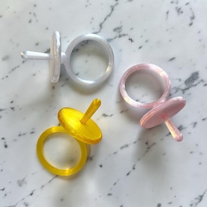 Puede incluir: Un juego de tres tazas de cerámica con acabado mate moteado. Las tazas son de color crema, gris claro y gris oscuro. Cada taza tiene un diseño simple y minimalista, ideal para café o té.