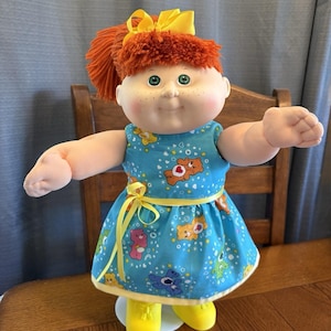 Lata 80., dzieciak z Cabbage Patch, rude włosy, zielone oczy, piegi, sukienka Care Bears