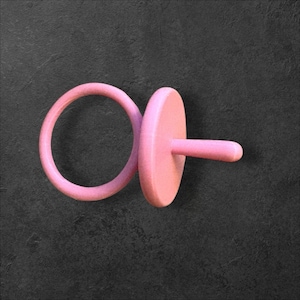 May include: A light pink pacifier with a round ring, a flat disc, and a cylindrical nipple. The pacifier is made of a solid material and is set against a dark gray background.