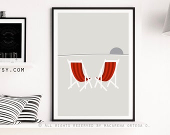 May include: A minimalist gray and white print with two red beach chairs facing a setting sun. The print is framed in black and hanging on a white wall.