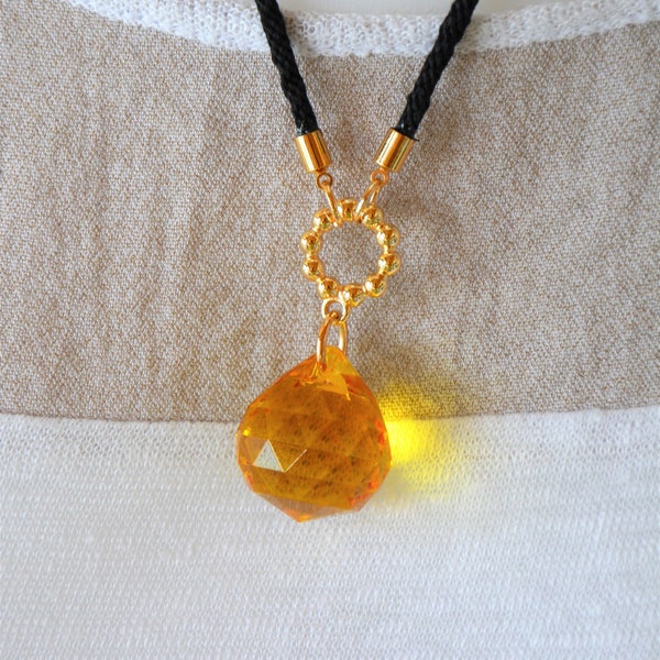 Petit collier avec un pendentif goutte, en cristal jaune et cordon noir.