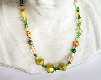 Halflange ketting van groene, witte en gouden Murano-parels.