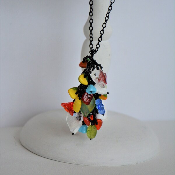 Collier mi long avec un pendentif en perles de verre multicolores.