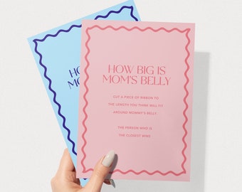 May include: Pink and blue cards with a wavy border. The pink card says "How big is Mom's belly?" and has instructions to cut a piece of ribbon to the length you think will fit around mommy's belly. The person who is the closest wins.