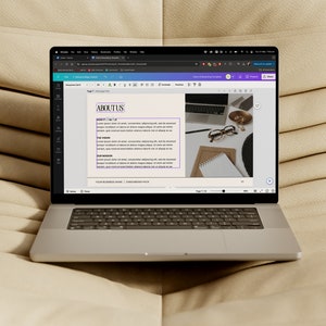 May include: A laptop computer displaying a web page with the heading "ABOUT US" and text about the company's vision, mission, and values. The laptop is on a beige couch.