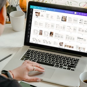 May include: A person working on a laptop computer with a white background. The laptop screen displays a document with the title "Social Media Strategy". The document is divided into sections with headings and text. The document is on page 23 of 23.