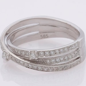 May include: A silver ring with three bands of diamonds. The ring is marked with the number "585".