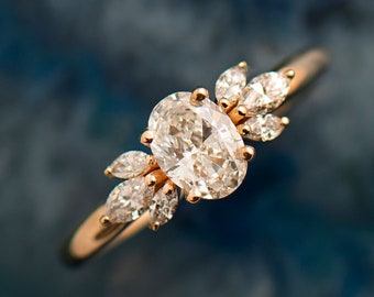 May include: A gold ring with a large oval-shaped diamond and smaller diamonds set in a delicate floral design.