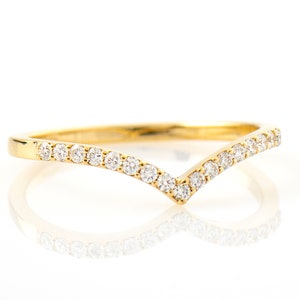 May include: A delicate gold band ring with a V-shaped row of small diamonds.