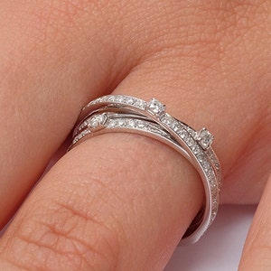 May include: A silver ring with multiple bands set with small diamonds.