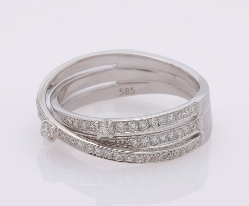May include: A silver ring with three bands of diamonds. The ring is marked with the number "585".