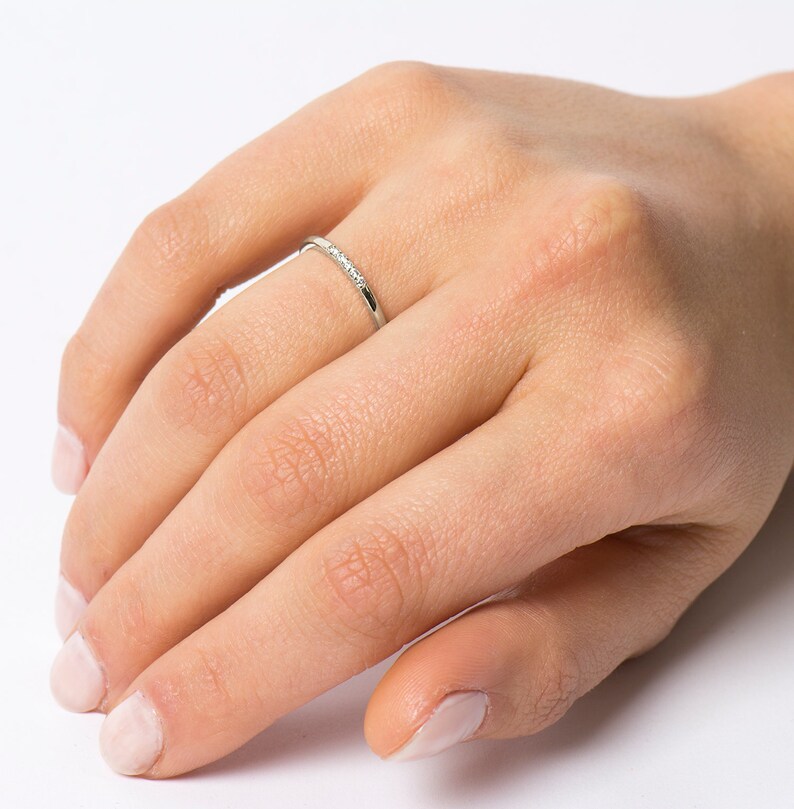 Op de afbeelding: Een dunne zilveren ring met kleine diamanten in een pav&eacute;-setting.