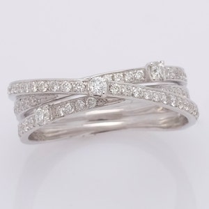 May include: A silver ring with three bands of diamonds that are intertwined. The ring has a larger diamond in the center.
