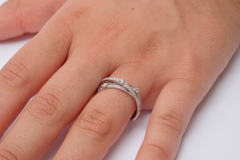 May include: A silver ring with multiple bands set with small diamonds.