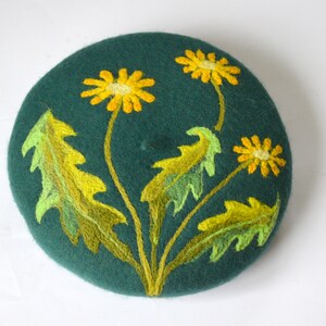 May include: A green felt beret with yellow and green embroidered dandelions.