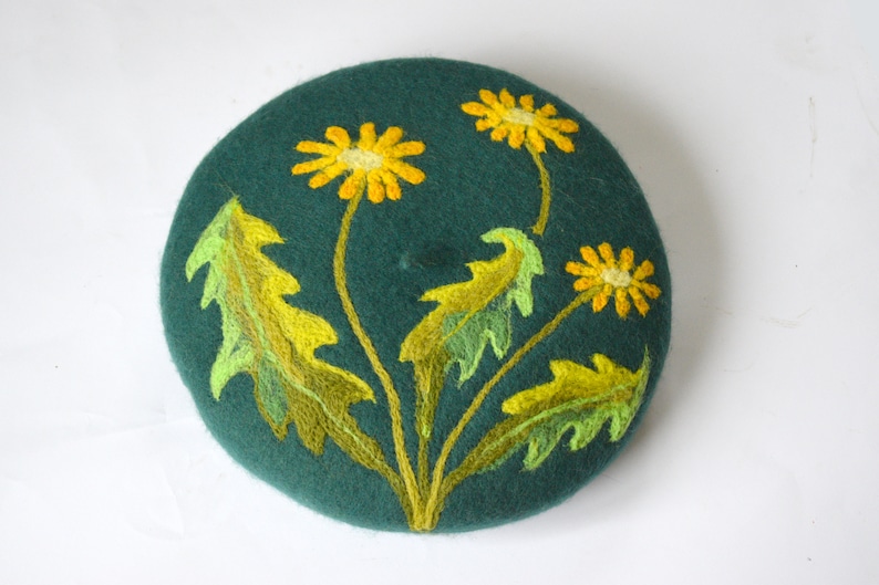 May include: A green felt beret with yellow and green embroidered dandelions.