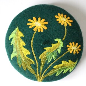 May include: A green felt beret with yellow and green embroidered dandelions.