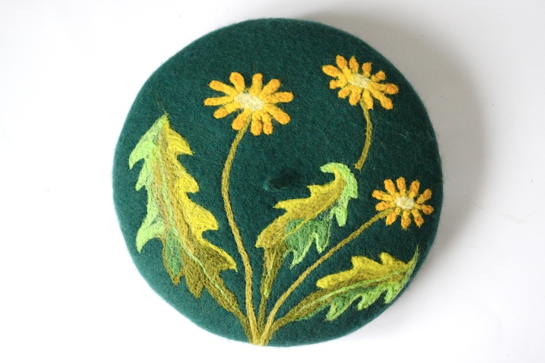 May include: A green felt beret with yellow and green embroidered dandelions.