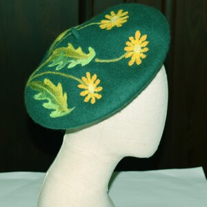 May include: A green felt beret with yellow embroidered flowers and green leaves.