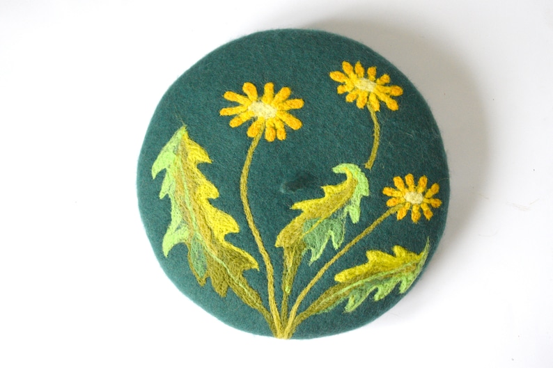 May include: A dark green felt beret with yellow and green embroidered dandelions.