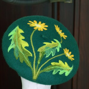 May include: A green felt beret with yellow and green embroidered dandelions.