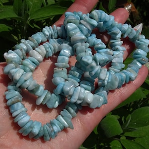 May include: A stack of blue and white gemstone chip bracelets. The chips are irregular in shape and have a light blue color with white inclusions.