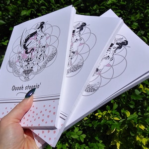 May include: Three white notebooks with a black and white illustration of a mermaid with a geometric pattern on the cover. The text "Ooooh stoonin'" is printed on the front cover of the notebook.