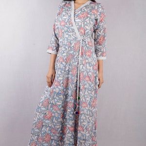 May include: A long, blue and pink floral print wrap dress with a tie at the waist. The dress has a V-neckline and three-quarter sleeves.