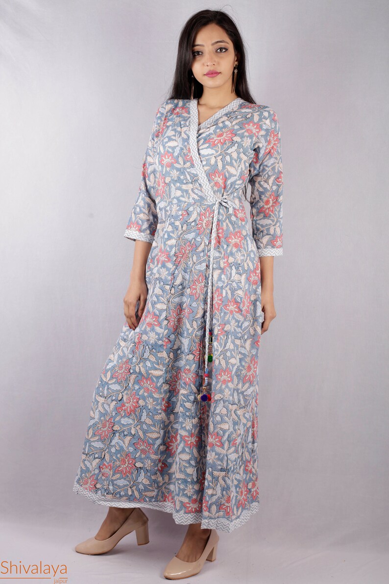 May include: A long, blue and pink floral print wrap dress with a tie at the waist. The dress has a V-neckline and three-quarter sleeves.