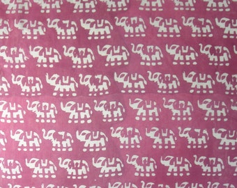 May include: Pink fabric with a repeating pattern of white elephant silhouettes. The elephants are stylized with geometric shapes, creating a bold and eye-catching design. The fabric has a soft, slightly textured appearance.