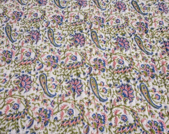 May include: White fabric with a repeating pattern of pink and blue flowers and green leaves. The fabric has a paisley design.