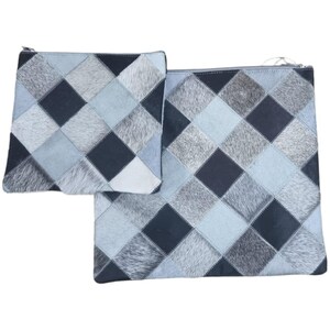 May include: Two gray and black patchwork leather zippered pouches. The pouches are made of different shades of gray and black leather with a diamond pattern.