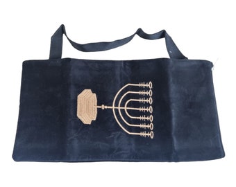 May include: Black velvet prayer shawl with a gold embroidered menorah design. The shawl has a strap for carrying.