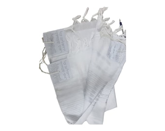 May include: White tallit with Hebrew text and fringes. The tallit is folded and has a white background with gray Hebrew text.