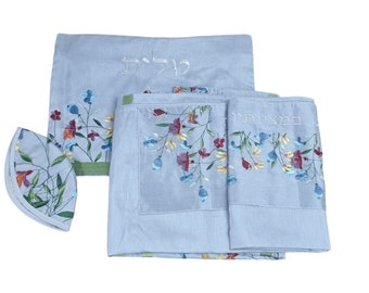 May include: A light blue tallit set with floral embroidery. The set includes a tallit, a tallit katan, and a kippah. The tallit and tallit katan feature a floral design with Hebrew text. The kippah has a floral design.