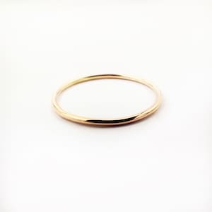 Op de afbeelding: Een eenvoudige gouden ring met een glad, afgerond oppervlak.
