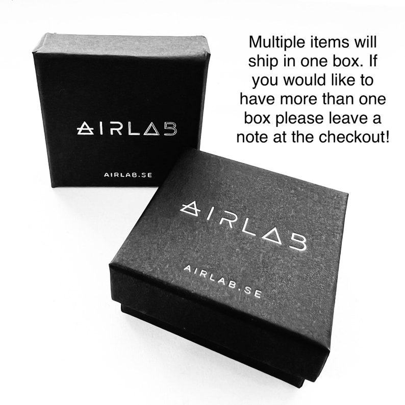 May include: Two black square boxes with the text "AIRLAB" and "AIRLAB.SE" printed in white on the top and bottom of each box.