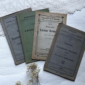 May include: Four vintage, bound books with German text on their covers. The books are titled "Präparationen für die Schullektüre", "Präparation Cacitus' German", "Präparation Xenophons Anabasis", and "Schülerpräpa zu latinischen and grivelischen".