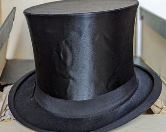 May include: A black top hat with a satin finish and a black grosgrain ribbon band.